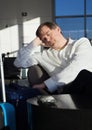 Tired businessman sleeping in airport terminal with luggage Royalty Free Stock Photo