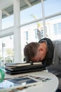 Tired businessman sleeping on files at desk Royalty Free Stock Photo