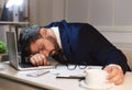 Tired businessman sleeping on laptop in the office Royalty Free Stock Photo