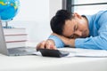 Tired businessman sleeping in the office. Asian business man  worked late and fell asleep on the computer keyboard. Tired male Royalty Free Stock Photo