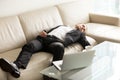 Tired businessman sleeping on sofa in office Royalty Free Stock Photo