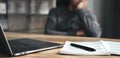 Tired businessman working on laptop with notepad and pen, resting head on hand, doing work overtime, stressed and bored Royalty Free Stock Photo