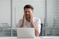 Exhausted male employee feel fatigue suffering from headache