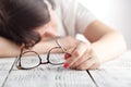 Tired businesswoman falling asleep at her workplace with eyes glasses