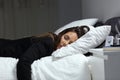 Tired businesswoman lying on a bed sleeping in the night