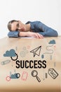 Tired businesswoman lying on table in office with success inscription