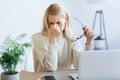 Tired businesswoman massaging nosebridge, working on laptop Royalty Free Stock Photo