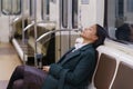 Tired african businesswoman sleep in subway carriage riding late from work overworked and exhausted