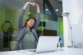 Tired businesswoman stretching her arms up at desk Royalty Free Stock Photo