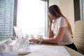 Tired businesswoman yawning at desk with laptop