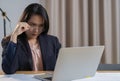 Tired busy young businesswoman feeling stress at workplace looking at laptop computer in office Royalty Free Stock Photo