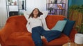 Tired young woman lying down on couch taking a rest at home, napping, falling asleep on orange couch Royalty Free Stock Photo