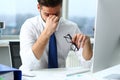 Tired clerk at laptop pc workplace wearing glasses Royalty Free Stock Photo