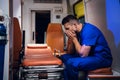 Tired corpsman in medical uniform sits inside the ambulance