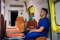 Tired corpsman sits inside the ambulance car