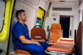Tired corpsman sitting inside the ambulance car, meditating