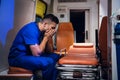 Tired corpsman in uniform sits inside the ambulance car