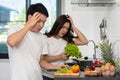 Tired couple cooking and preparing vegetables in kitchen at home Royalty Free Stock Photo