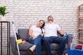 Tired Couple Sitting On Sofa