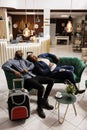Tired couple taking nap in hotel lobby Royalty Free Stock Photo