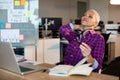 Tired creative businesswoman sitting on desk