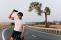 Tired cyclist in helme splashing water from bottle Royalty Free Stock Photo