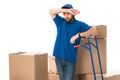 tired delivery man standing between cardboard boxes and looking away Royalty Free Stock Photo