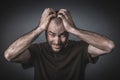 Tired and depressed man holds his head with both hands