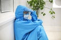 Tired depressed nurse in personal protective equipment PPE after difficult shift during Covid-19 Royalty Free Stock Photo