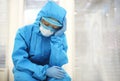 Tired depressed nurse in personal protective equipment PPE after difficult shift during Covid-19 Royalty Free Stock Photo