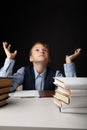Tired and depressed school boy sitting at the desk and studying alone. Royalty Free Stock Photo