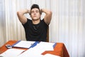 Tired or despondent young man doing homework Royalty Free Stock Photo