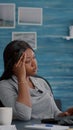 Tired disappointment black student having headache sitting at desk searching medical treatment