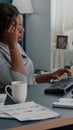 Tired distressed black student suffering headache sitting at desk table in living room