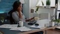 Tired distressed black student suffering headache sitting at desk table in living room