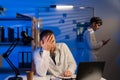 Tired doctor with headache on duty at night in hospital with colleague young doctor Royalty Free Stock Photo