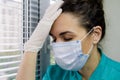 Tired Doctor italian woman in medical mask, gloves and doctor`s suit closed her eyes and propped her head against Royalty Free Stock Photo