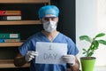 Tired doctor in protective uniform announces one day before the end of the coronavirus pandemic. Male medic holds a