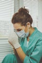 Tired Doctor woman in medical mask, gloves and doctor`s suit closed her eyes and praying Royalty Free Stock Photo