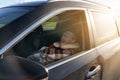 A tired driver sleeps in the car during the day, covered with a blanket and wearing a sleep mask over his eyes. Royalty Free Stock Photo