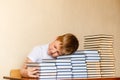 Tired eight-year-old boy sleeping on books at the table. children and reading Royalty Free Stock Photo