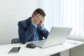 a tired employee at work in front of a computer monitor. Thoughtful businessman looking at his laptop. annoying work. A