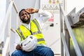 Tired engineer african american man in uniform is sit down on the stairs in the windmill area Royalty Free Stock Photo