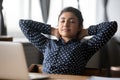 Tired ethnic woman relax in chair at workplace Royalty Free Stock Photo