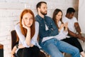 Tired excited female job candidates looking at camera while waiting interview with hr sitting in queue line row with Royalty Free Stock Photo