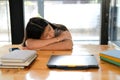 Tired exhausted girl student sleeping after studying hard exam in library Royalty Free Stock Photo