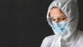 Tired exhausted doctor or nurse in PPE suit on dark background, COVID-19 concept Royalty Free Stock Photo