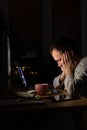 Tired exhausted freelancer man sitting at a desktop PC / laptop late at night, falls asleep from fatigue, taking work at home Royalty Free Stock Photo