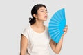 Tired exhausted Indian girl waving fan, suffering from heat Royalty Free Stock Photo