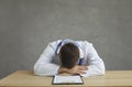 Tired and exhausted male doctor sleeps sitting at a table after a hard day's work.